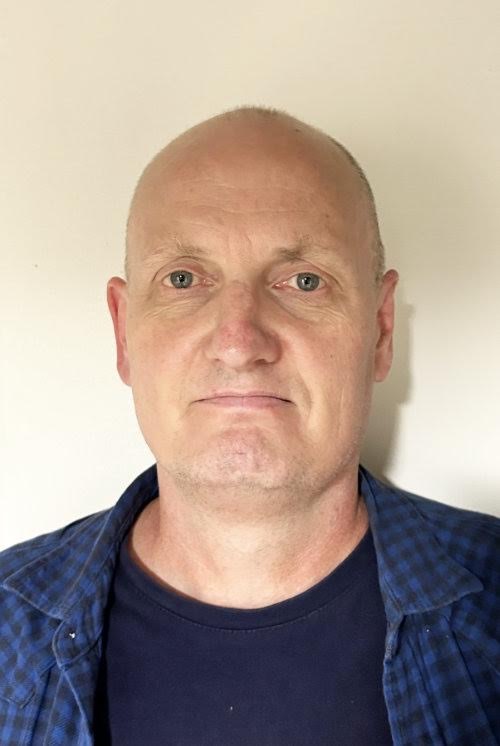 Photo of Stefan Bauschmid in front of a beige wall.